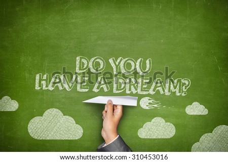 Do you have a dream concept on green blackboard with businessman hand holding paper plane