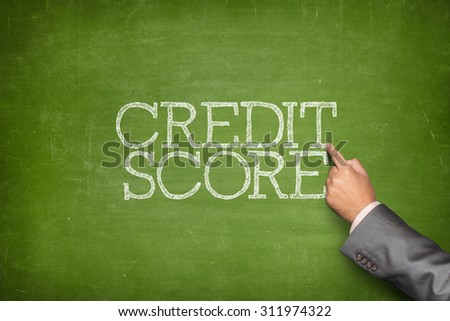 Credit score text on blackboard with businessman hand pointing
