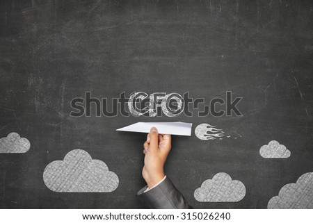 CFO concept on black blackboard with businessman hand holding paper plane