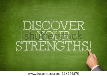 Discover your strengths text on blackboard with businessman hand pointing