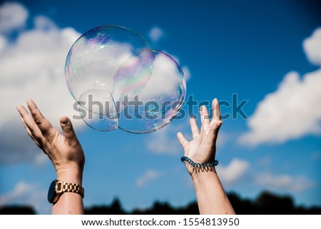 Some one trying to catch soap bubbles. Hands trying to catch  floating soap bubbles Stock foto © 