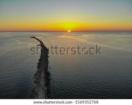 Foto Bild Langer Wellenbrecher im türkisfarbenen Meer an einem sonnigen Tag