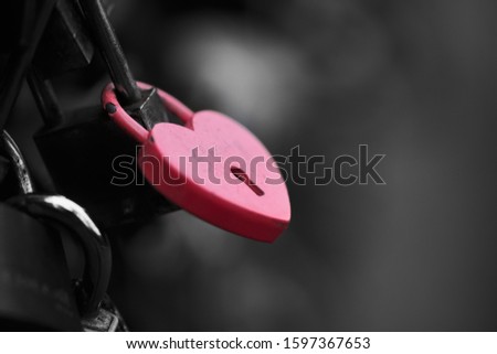 The red heart shape padlock hanging in the middle of many blurred padlocks that around and all are at the fence of the bridge in Paris, France. Concept Padlocks Love forever. Valentine. Stockfoto © 