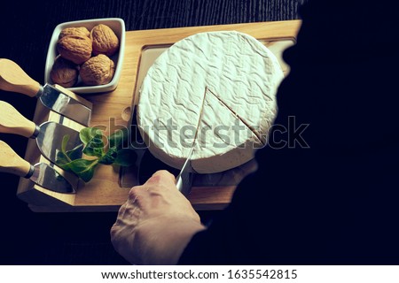 Closeup on woman cutting fresh cheese at desk. Stockfoto © 