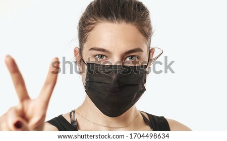 A close-up portrait of a pretty female wearing a surgical mask isolated on a white background Photo stock © 