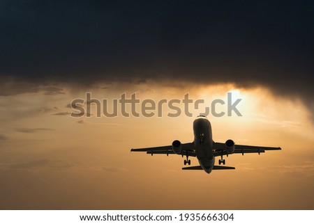 Plane goes on takeoff at sunset. Landing plane at sunset. Cloudy sky Stock foto © 