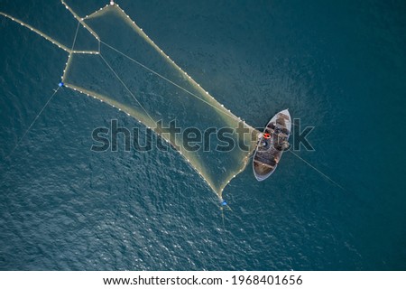 Vintage wooden boat in coral sea. Boat drone photo. A fisherman on a fishing boat is casting a net for catching fish. Stock foto © 