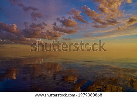 Beautiful sunset over sea with reflection in water, majestic clouds in the sky. Сток-фото © 