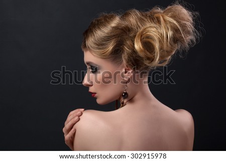 Girl with blond hair with black eye shadows from behind retro vintage