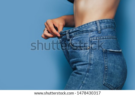 skinny woman body with Loose pants jeans, Light weight body with loose clothes, slender and Healthy body low fat concept. Foto stock © 