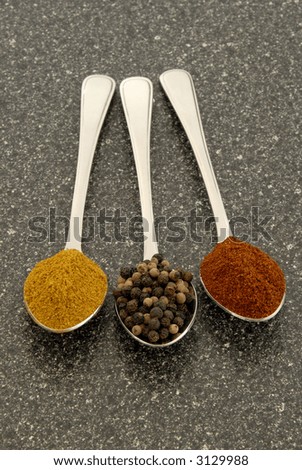 Curry Powder, Black Peppercorns And Chili Powder, Measured Out On Teaspoons