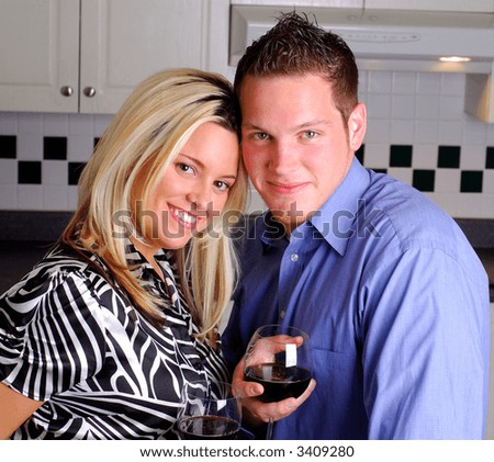 Young Couple In Love Enjoying A Glass Of Wine At Home In The Kitchen