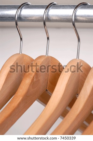 Empty Wooden Coat Hangers Hanging From A Storage Rail