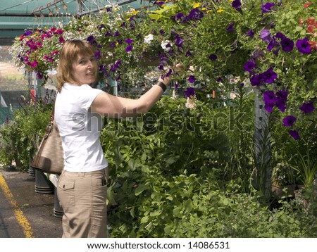 Middle Age Woman Shopping For Plants At A Garden Center