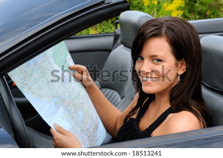 Woman Looking For Direction On A Map In Her Sports Car