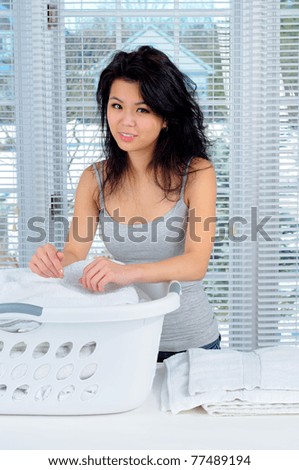 Pretty Chinese Girl With Long Hair Doing Laundry At Home
