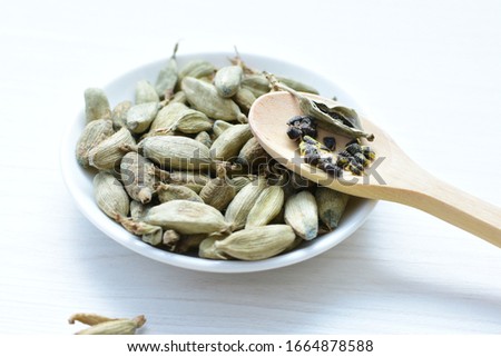 Semilla de cardamomo seco (Elettaria cardamomum) exhibidos en recipientes y cucharas Zdjęcia stock © 