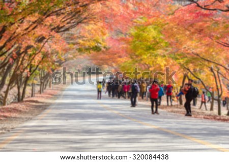 Blurred image of people walking in an autumn park.Blurred background