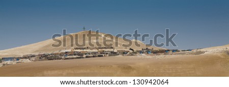 Peru view: Poor houses sited in the peruvian desert with a cross domain the hill