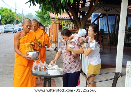 Chonburi, THAILAND - September 05 2015: Buddhist give food offerings to a Buddhist monk in morning at Nuchanard village road Thailand
