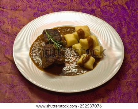 Roasted wild game in ginger bread sauce with potato dumplings
