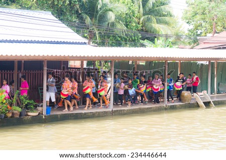 SAMUTSONGKHRAM, THAILAND - OCTOBER 12: Group of people participated Kathin\'s festival day in buddhist culture at Maeklong river by play a tall narrow drum or called \