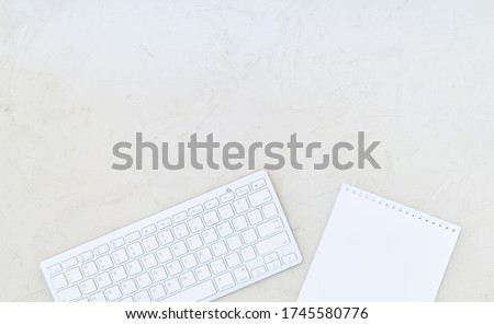 Changing table, white wireless keyboard and notebook with blank sheet on a wooden surface. Copy space ストックフォト © 