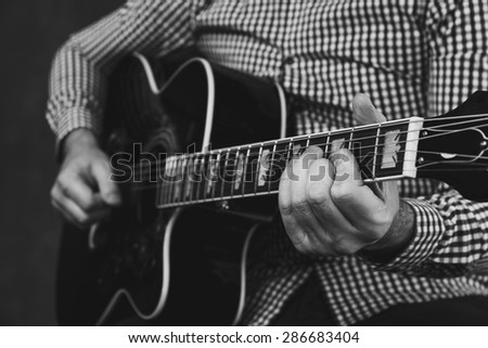 acoustic guitar tuning and playing close up in studio