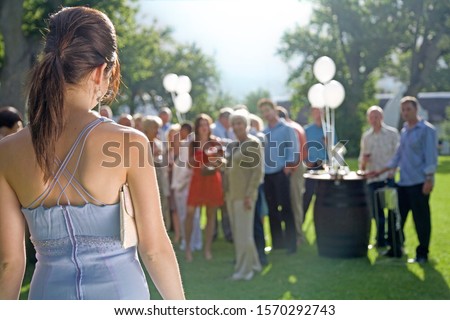 A young woman arriving at a summer garden party