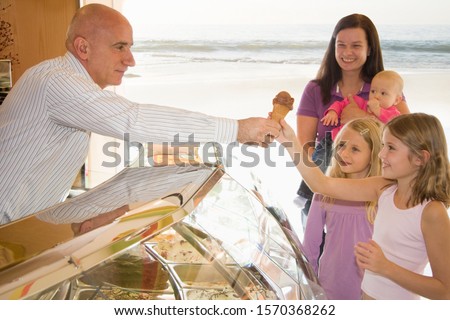 Une mère et trois enfants qui achètent de la glace
