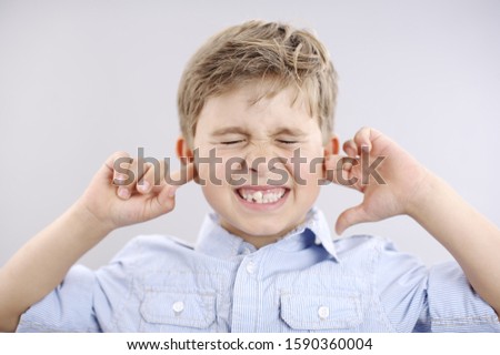 Young boy with fingers in ears