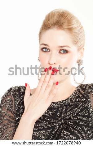 Glamorous young woman with hand over mouth, portrait