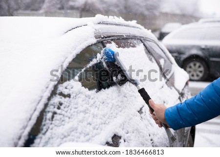 Man cleaning snow with car brush Imagine de stoc © 
