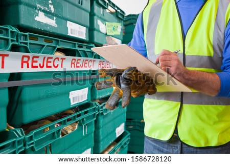 Worker With Rejected Produce In Food Processing Warehouse