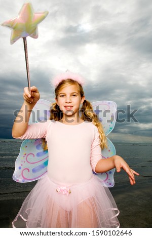 A young girl wearing a fairy costume