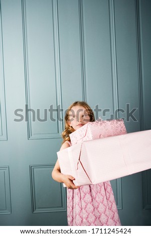 little girl carrying presents in front of a door way