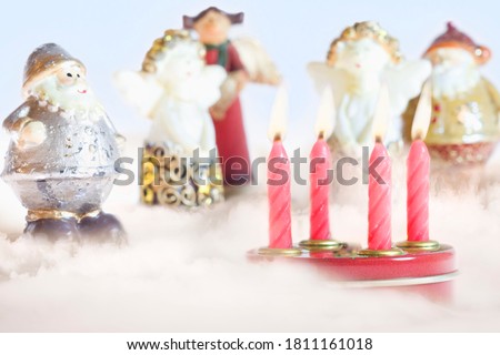 Christmas figurines and candles on a light surface.