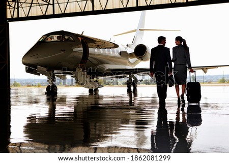 Wide shot of a businesswoman and a businessman walking towards private jet Foto stock © 