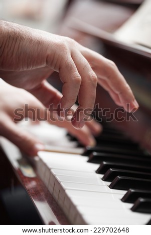 Pianist hands playing piano. Selective focus on foreground hand.