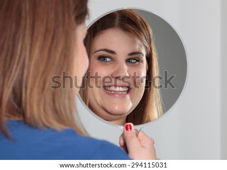 Smiling woman looking into the mirror