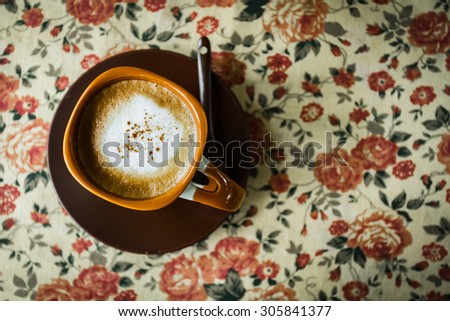 Top view Coffee Cup on the table cloth floral vintage style, vintage style photo.