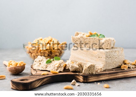 Pieces of sunflower and peanut halva and mint leaves on a cutting board on the table. Caloric oriental dessert Foto stock © 