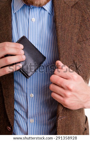 Man pulls out a wallet with money from the jacket