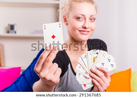 Happy woman holding a ace card during the game