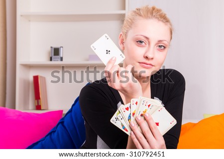 Portrait of a girl playing cards at her home