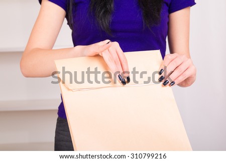 Woman seals envelope before sending by post