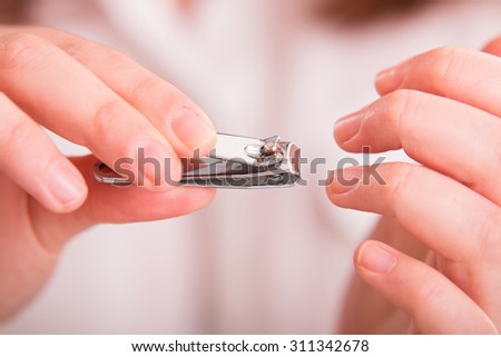 Cutting nails using nail clipper - close up