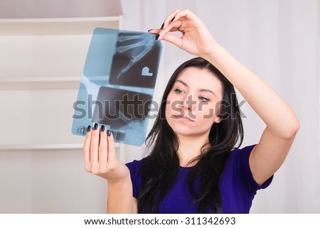 Young women looks at x-ray image at home