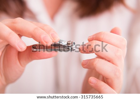 Cutting nails using nail clipper - close up