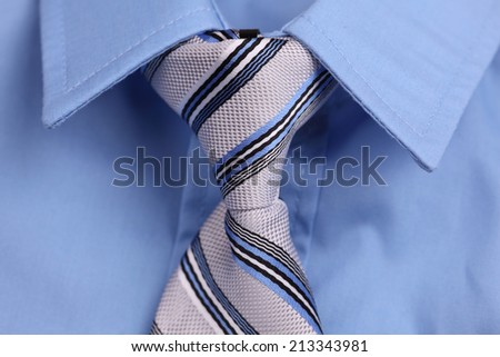 Closeup of blue shirt and necktie.